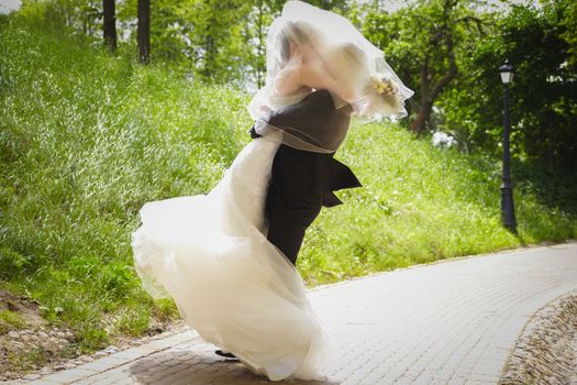 The bride and groom on the wedding day spinning hugging each other