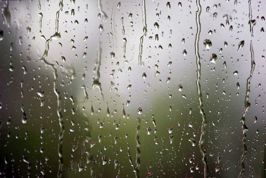 Close-up of raindrops running down the glass.Texture or font