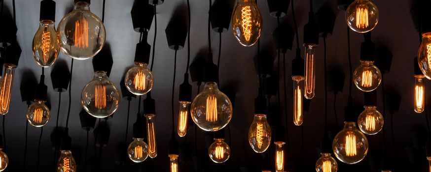 Install a retro Edison lamp on a black ceiling background. Concept idea.