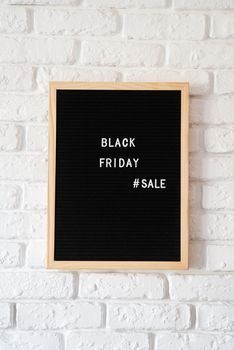 Black friday, seasonal sale concept. Text black friday sale on black letter board on white brick wall