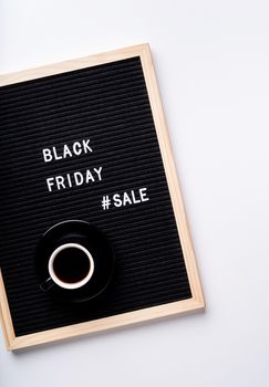 Black friday, seasonal sale concept. Text black friday sale on black letter board with cup of coffee on white background