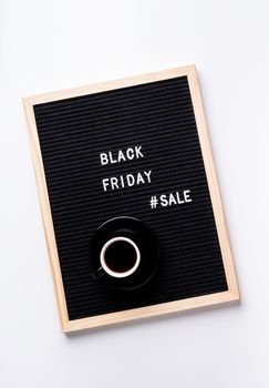 Black friday, seasonal sale concept. Text black friday sale on black letter board with cup of coffee on white background