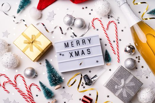 New Year and Christmas flat lay. Lightbox with the words Merry Xmas top view on white background with confetti and decorations flat lay