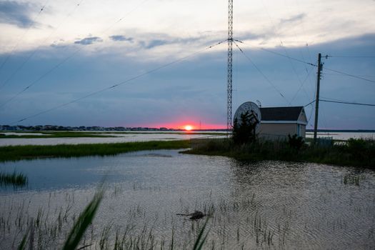 A Red Sunset Next to a Large Metal Radio Tower at the Bay in Wildwood New Jersey