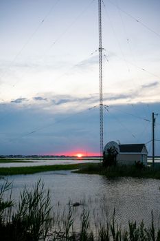 A Red Sunset Next to a Large Metal Radio Tower at the Bay in Wildwood New Jersey