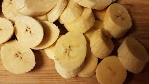 sliced plantain banana fruit on wood cutting board