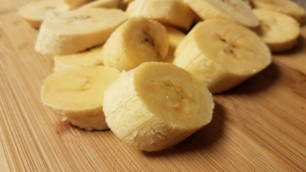 sliced plantain banana fruit on wood cutting board