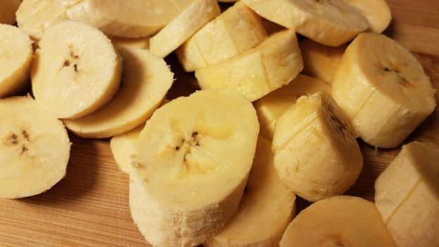 sliced plantain banana fruit on wood cutting board