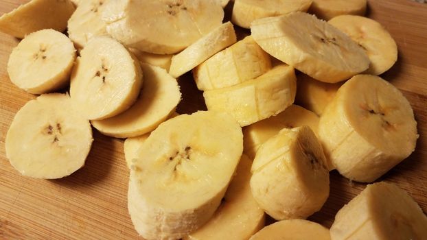 sliced plantain banana fruit on wood cutting board