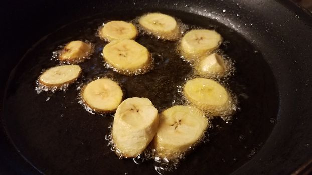 plantain banana from Puerto Rico boiling in oil in frying pan