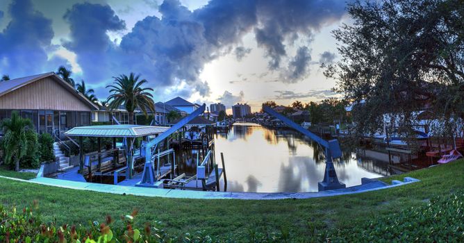 Boat lift in a waterway at sunset in Naples, Florida