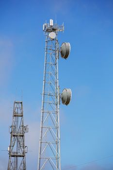 Modern technology communication towers against a clear blue sky