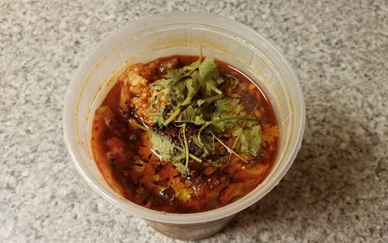 Chinese spicy fish and garlic in chili oil in plastic container