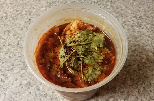 Chinese spicy fish and garlic in chili oil in plastic container