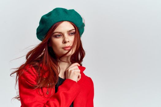 Woman in red coat and in green hat on isolated background cropped model with Copy Space emotions. High quality photo