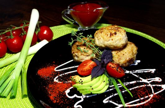 A beautifully designed dish of fried cutlets with cherry tomatoes and zucchini