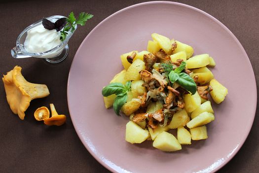 On the table dishes potatoes with mushrooms and sauce