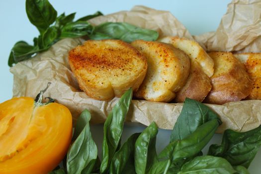 On the paper there are toasted slices of baguette with greens close up