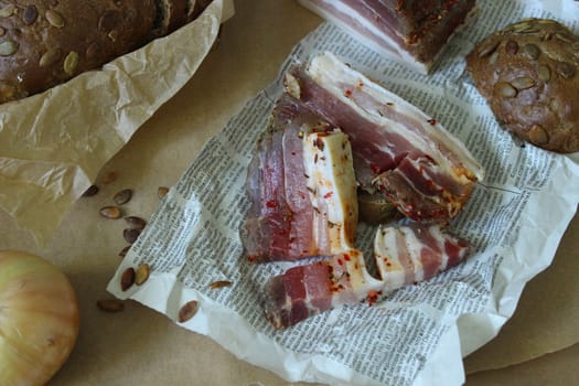 Pieces of sliced bacon lie on the newspaper.Texture or background