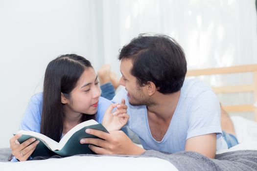 Couple reading a book together in bedroom on the morning with happiness.