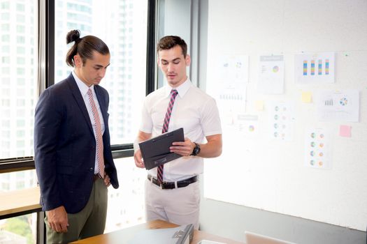 Asian young businessman two people holding clipboard and discussing work in the meeting room, business concept.