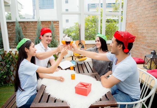 Asian group people drinking at party outdoor. group of friends cocktails in hand with glasses.