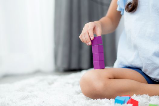 Close up of hand child playing with colorful plastic block at floor. Early learning developing to children with toys.