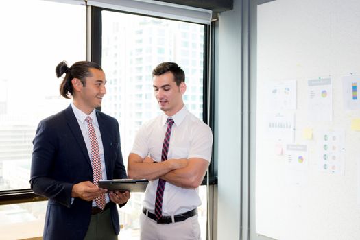 Asian young businessman two people holding clipboard and discussing work in the meeting room, business concept.