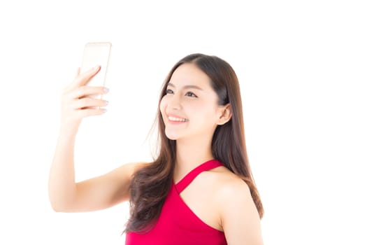Smiling asian young woman takes a selfie on smartphone. girl takes photo with phone.