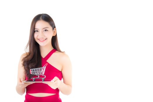 Smiling asian woman in red dress holding tablet with glad girl and cart on tablet isolated on white background.