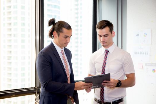 Asian young businessman two people holding clipboard and discussing work in the meeting room, business concept.