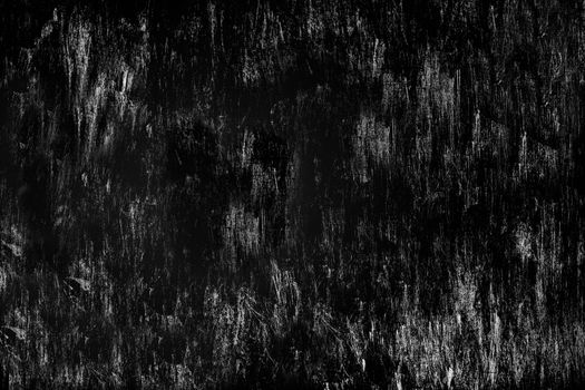 Heavily scratched surface of the stone wall aged by time black color. Texture or background