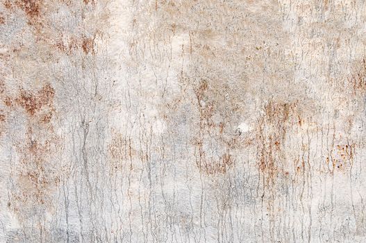 Rusty metal surface with peeling white paint on it