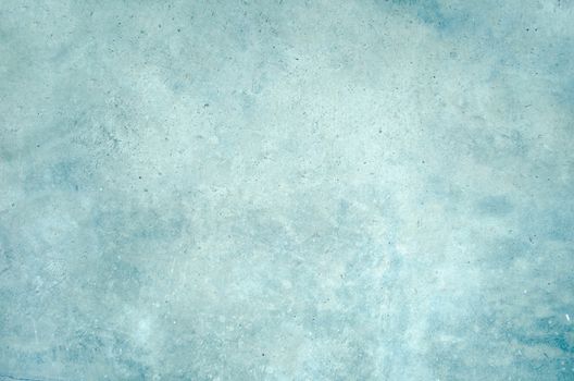 Bare untreated plaster wall with a rough textured surface in shades of blue