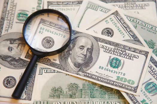 On the hundred dollar bills is a magnifying glass .Texture.Background.