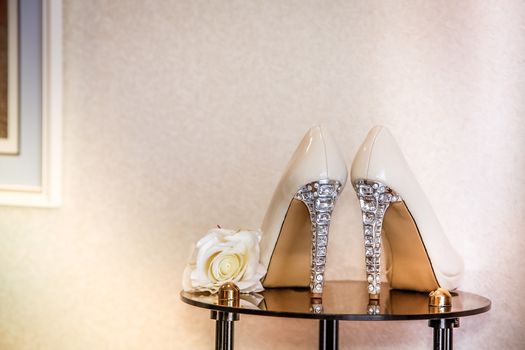 Wedding shoes with high heels are on the mirror table