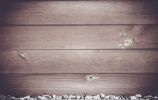 Horizontal wooden Board dark brown with bitches on the surface and small stones at the bottom .Texture.Background.