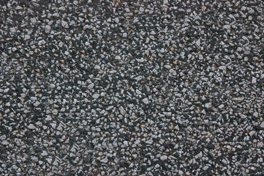Asphalt roadway with uneven dark gray textured surface .Texture or background.