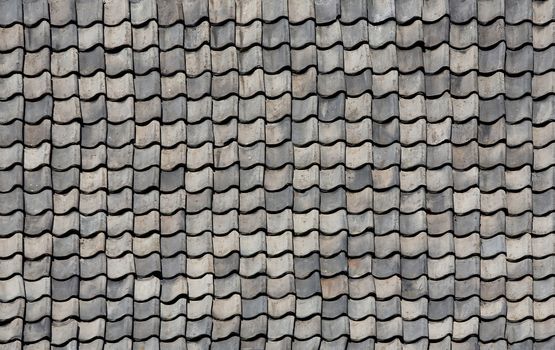 Gray natural tiles on the roof of the old building.Texture or background.