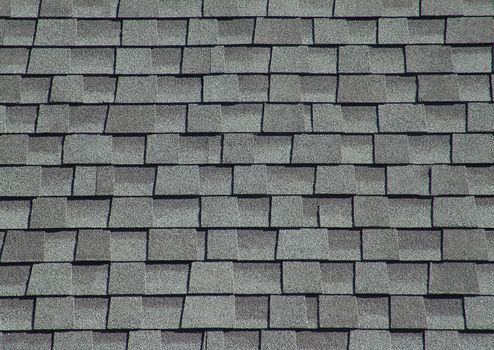 The roof is covered with soft shingles in the form of geometric plates of gray color.Texture and background.