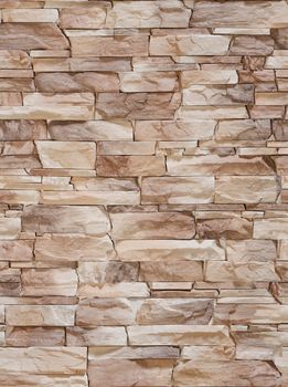 A fake stone in the form of a sharp bumpy coffee-colored tile .Texture or background.