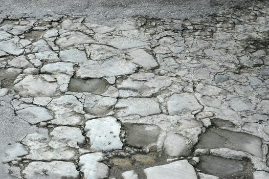 The old crumbling asphalt driveway with a textured surface