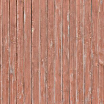 Outdated fence boards with peeling red paint on it.Background or texture