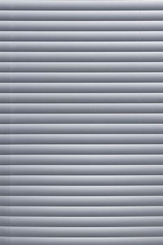 The window has horizontal gray blinds. Texture or background