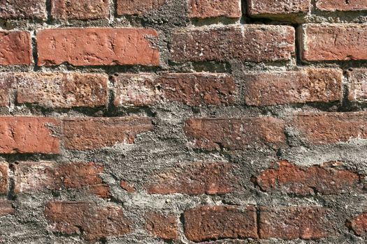 The wall of the old house is made of red brick with a textured surface .Texture or background