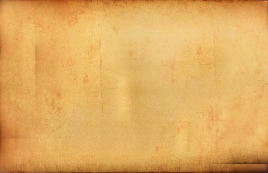 Aged yellow-brown paper with burnt edges and yellow spots .Textures or background