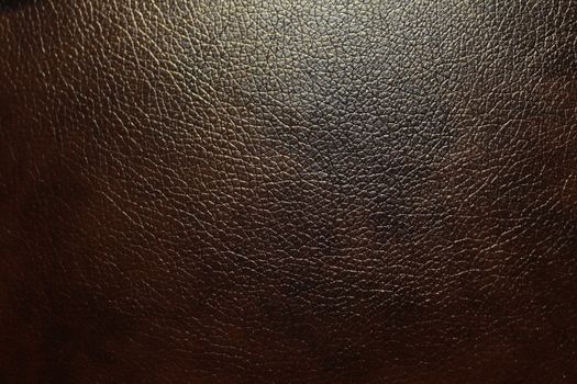 Abstract dark brown faux leather with a rough textured surface