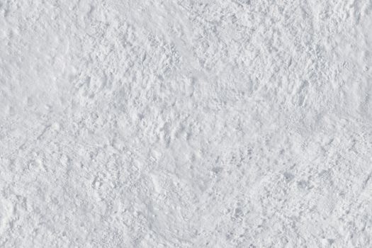 White snow close-up with an uneven rough surface .Texture or background