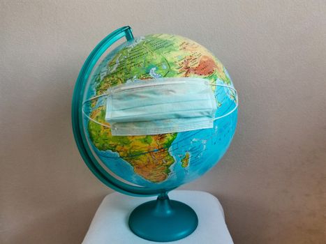 The globe of the planet earth is wearing a disinfecting face mask.Texture or background