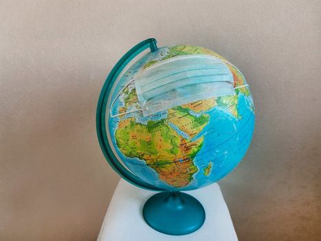 The globe planet earth is wearing a disinfecting surgical face mask.Texture or background